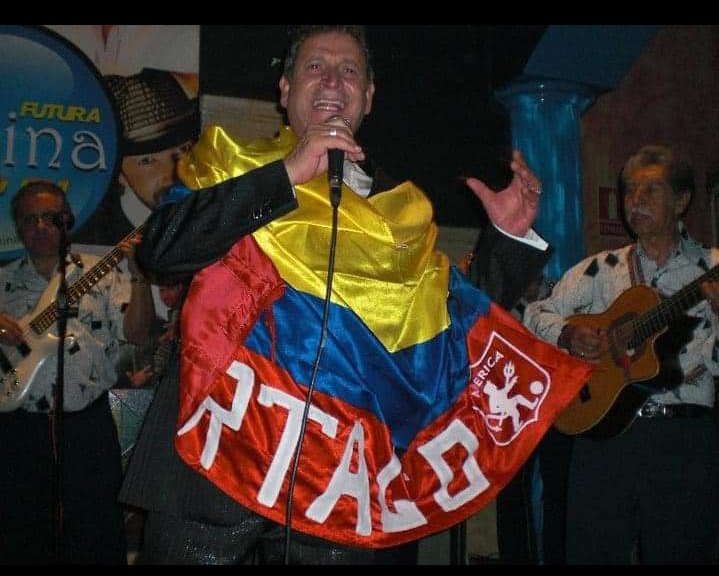 Foto de Darío Gómez con una bandera del América de Cali